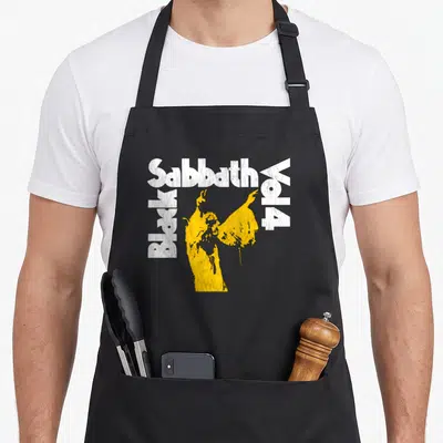 Sabbath vol black officially apron - Distressed white text framing a yellow person silhouette — shown on a black cotton canvas apron against a white background