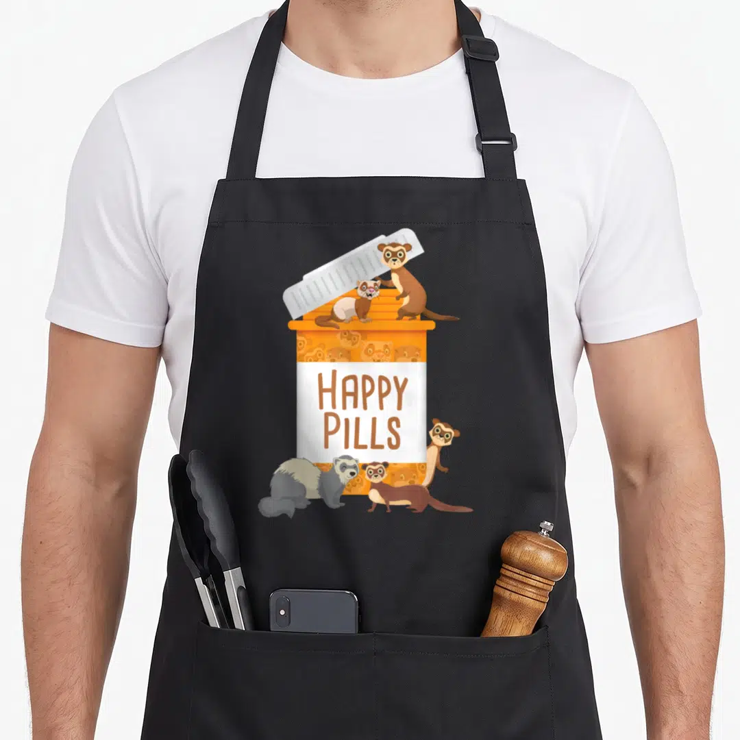 Pill animal apron - Cartoon orange pill bottle with HAPPY PILLS text and ferrets perched around it — shown on a black cotton canvas apron against a white background