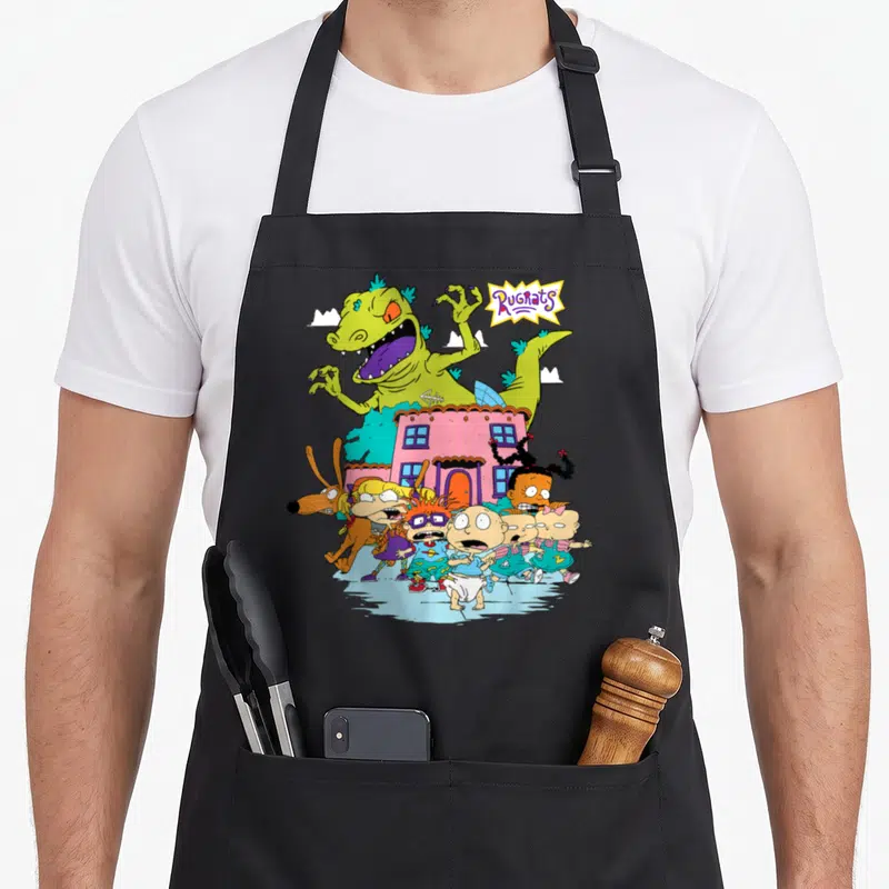 Away running apron - Rugrats logo, green monster, five babies, pink house, cartoon chase scene — shown on a black cotton canvas apron against a white background