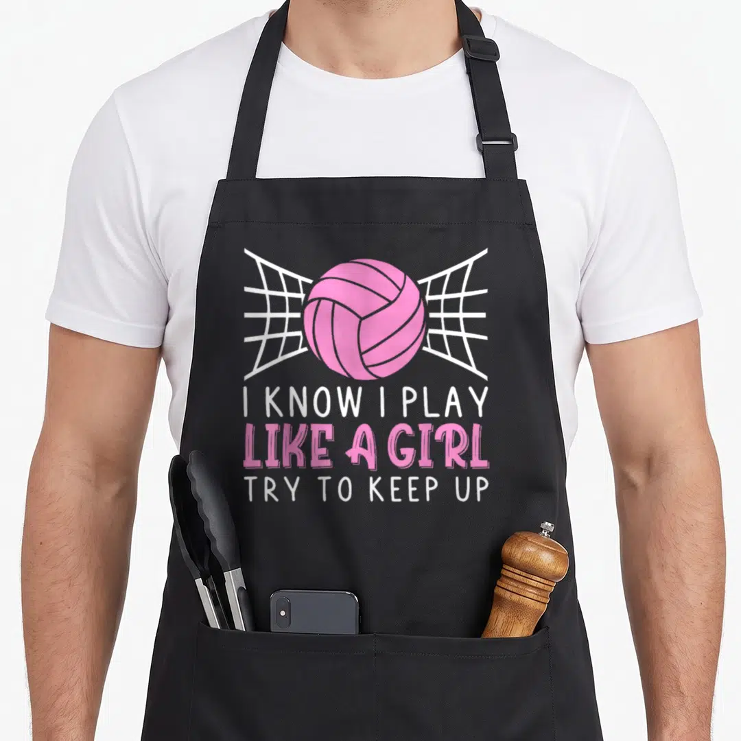 Vintage player volleyball apron - Pink volleyball over white net with text I KNOW I PLAY LIKE A GIRL TRY TO KEEP UP — shown on a black cotton canvas apron against a white background