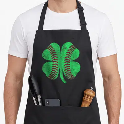 Saint st patrick day aprons - Green four-leaf clover with red baseball stitching running vertically through the leaves — shown on a black cotton canvas apron against a white background