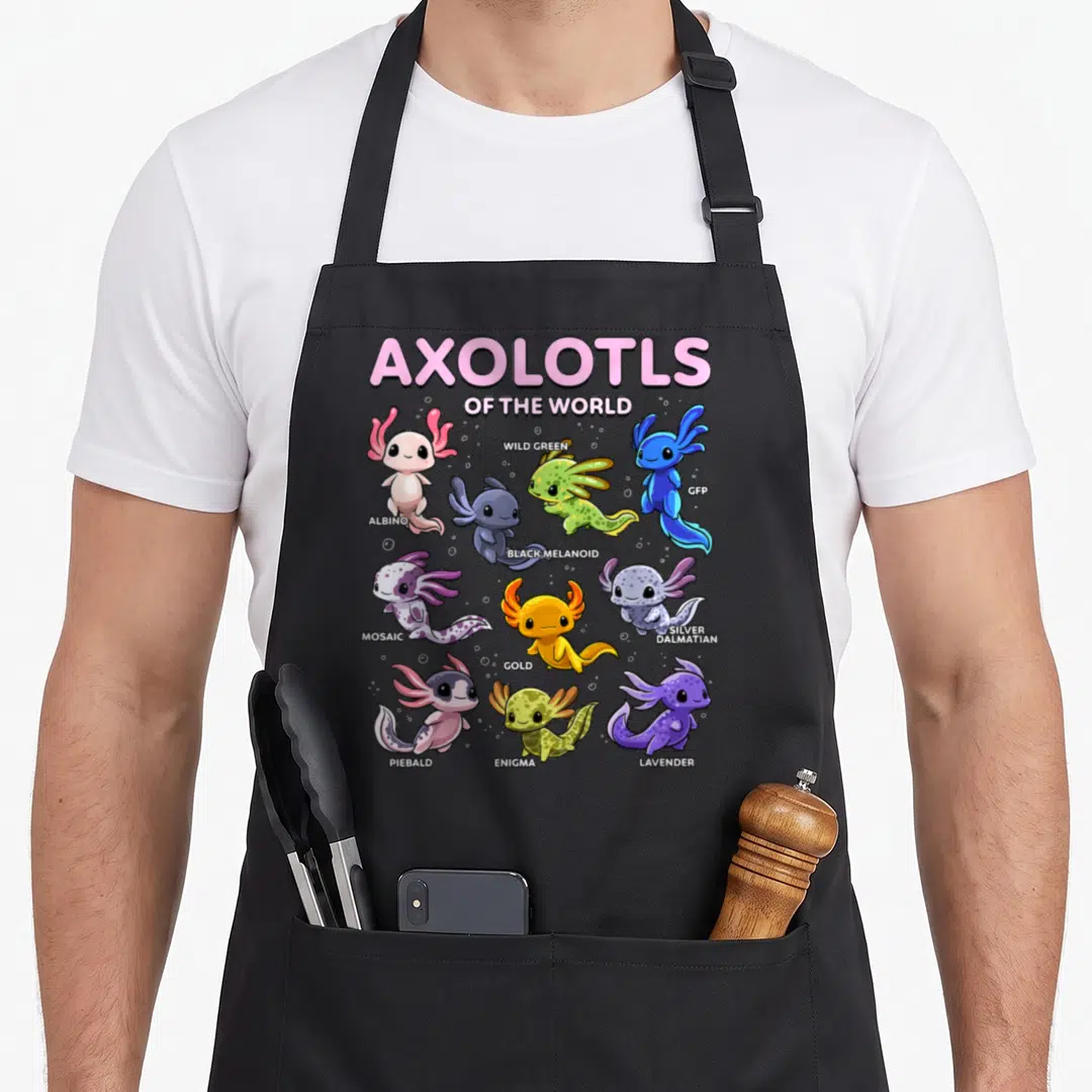 Axolotl kawaii apron - Nine cartoon axolotls in pink, green, blue, purple, and gold with variety labels — shown on a black cotton canvas apron against a white background