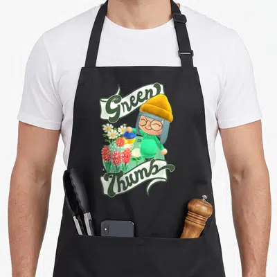 Horizon gaming boys apron - Cartoon character watering red and white flowers between ribbons reading Green Thumbs — shown on a black cotton canvas apron against a white background