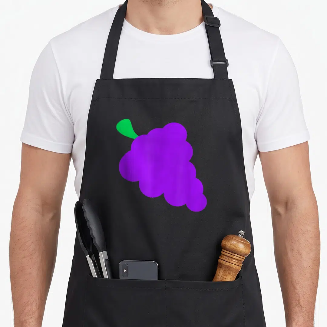 Funny grapes apron - Minimalist purple grape cluster with single green leaf on black bib — shown on a black cotton canvas apron against a white background