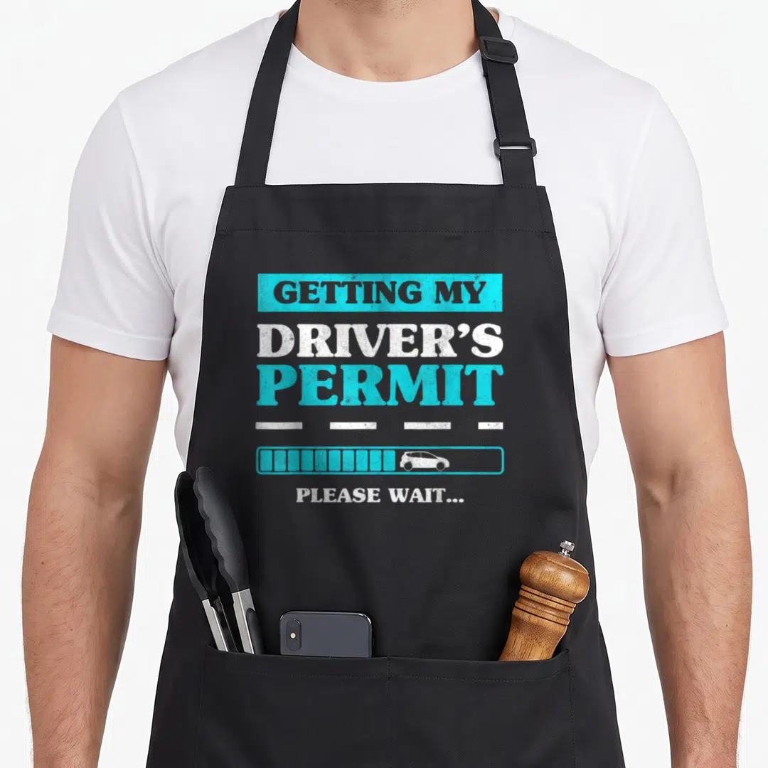 Permit congratulations apron - Stacked text Getting My Driver's Permit Please Wait loading bar car dashed lines — shown on a black cotton canvas apron against a white background