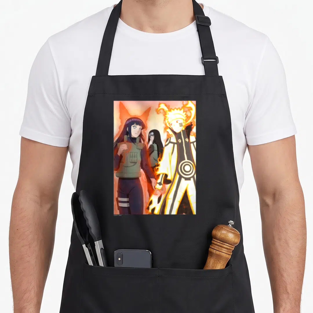 Shippuden couple apron - Naruto Uzumaki and Hinata holding hands surrounded by orange flames with Hanabi in background — shown on a black cotton canvas apron against a white background
