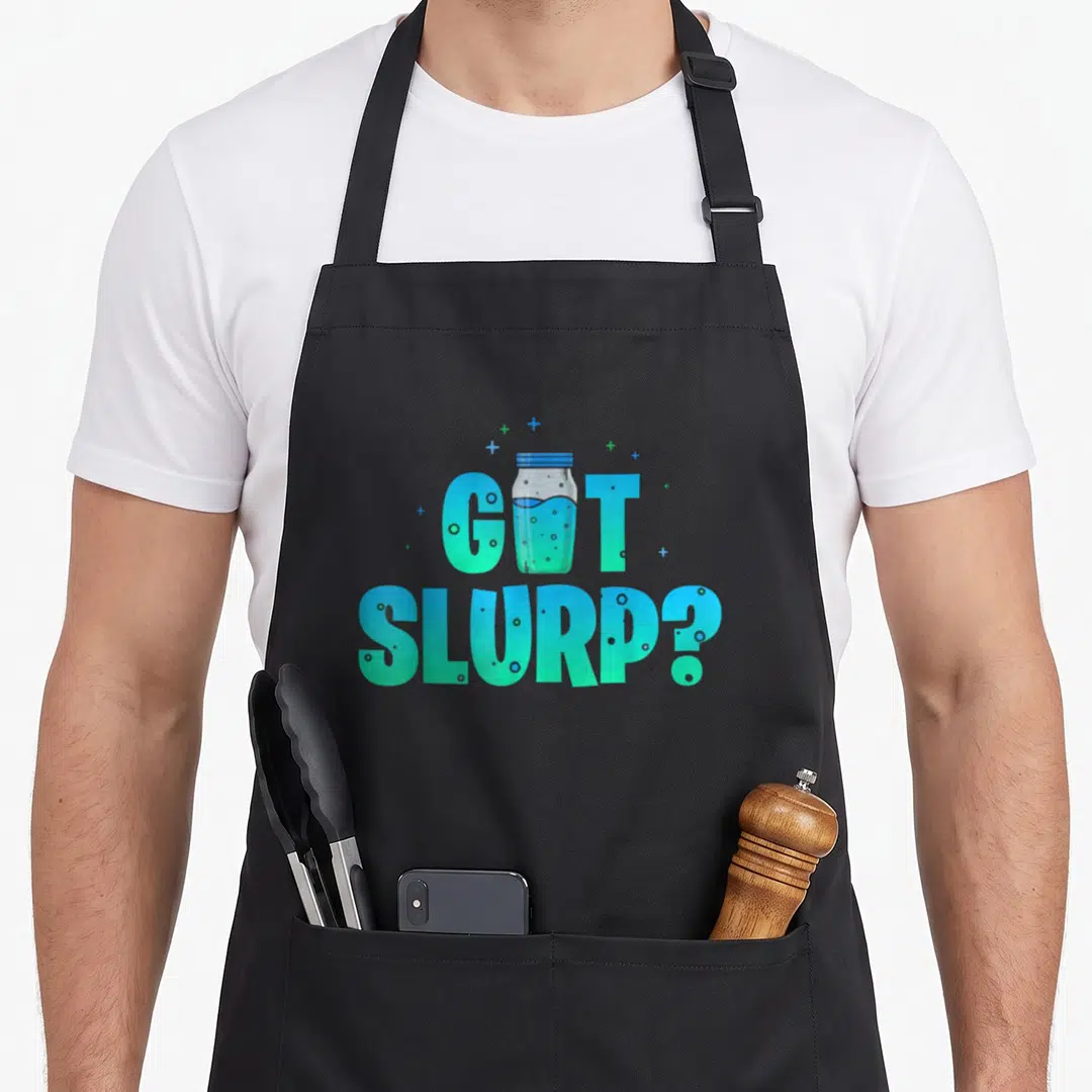 Slurp meme apron - GOT SLURP? text with blue mason jar and cyan bubbles — shown on a black cotton canvas apron against a white background