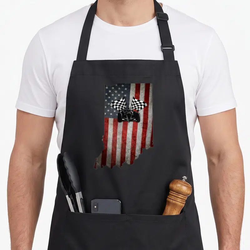 Indiana distressed apron - Indiana state map silhouette filled with red white blue flag and black race car with two — shown on a black cotton canvas apron against a white background