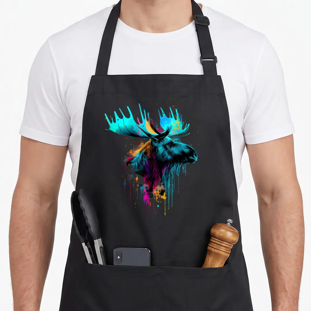 Moose colorful aprons - Cartoon moose head with dripping cyan blue purple orange yellow paint splatters — shown on a black cotton canvas apron against a white background
