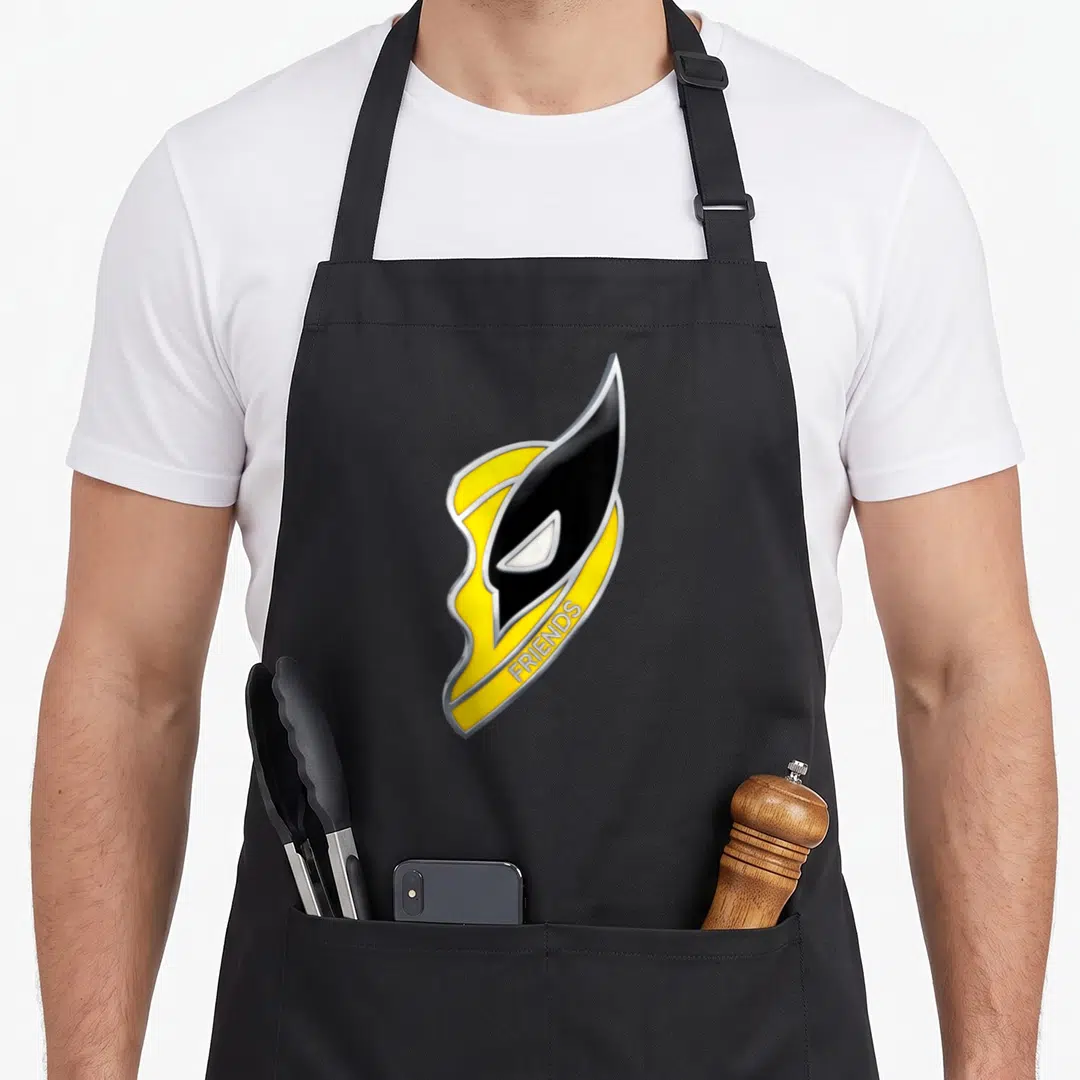 Studio best friend aprons - Stylized yellow and black mask with FRIENDS text in silver outline — shown on a black cotton canvas apron against a white background