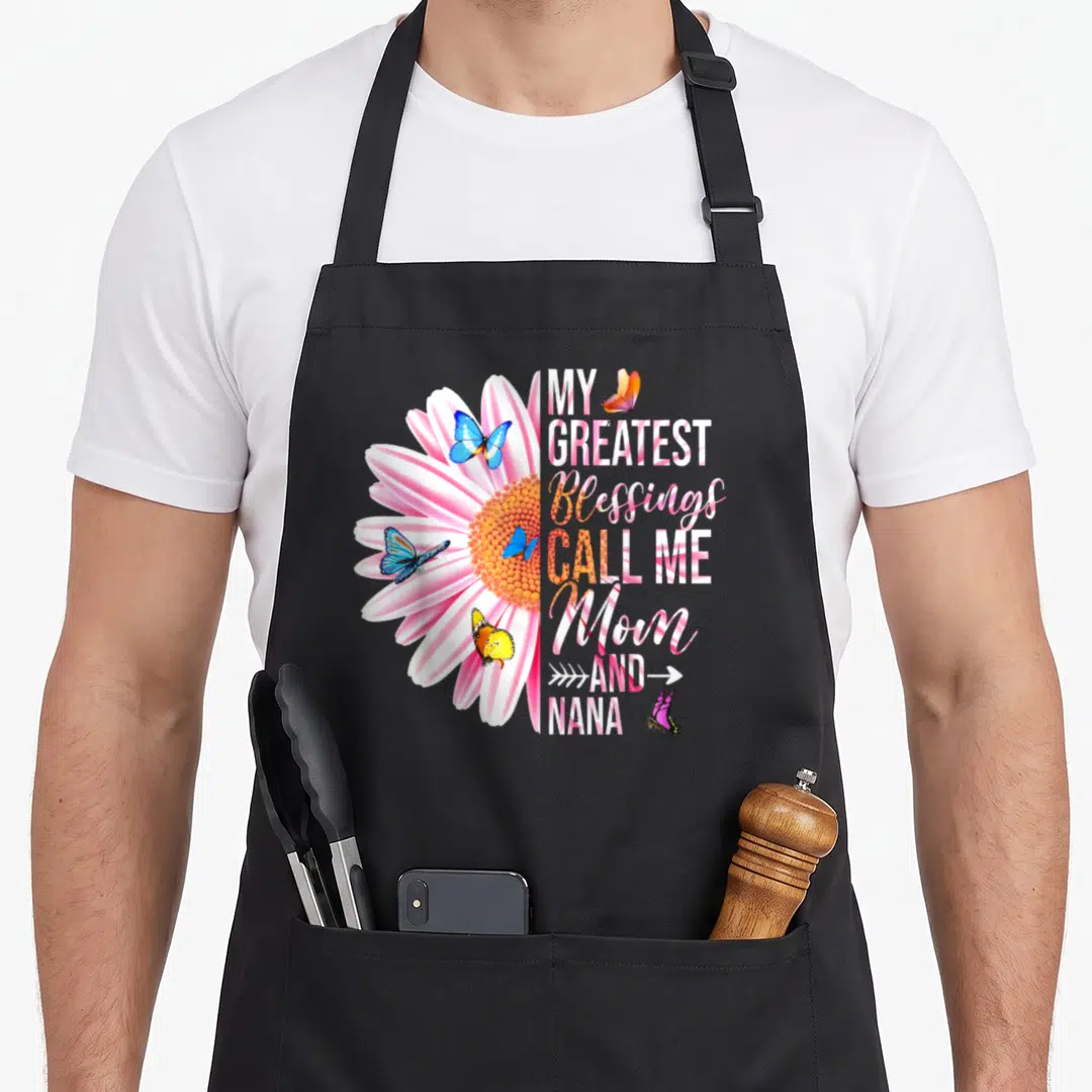 Greatest blessing mother's day aprons - Pink daisy with blue and yellow butterflies next to stacked text reading My — shown on a black cotton canvas apron against a white background