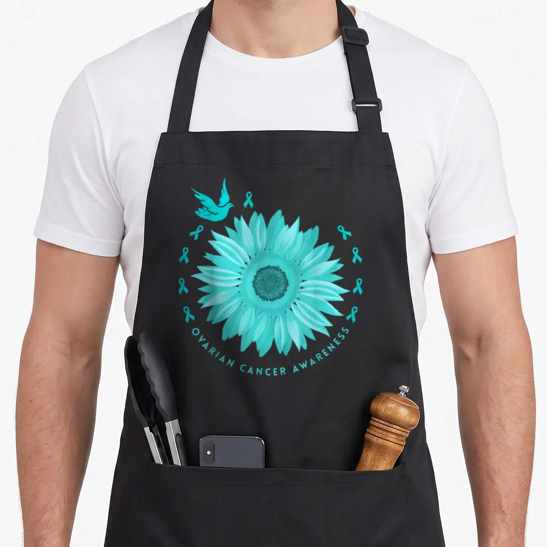 Retro ovarian cancer awareness apron - Teal sunflower with bird and ribbons, arched text reading Ovarian Cancer — shown on a black cotton canvas apron against a white background