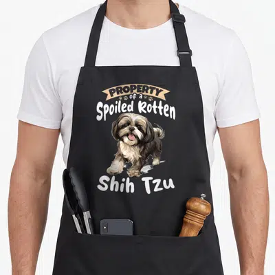 Tzu pet dog apron - Cartoon Shih Tzu with PROPERTY of a Spoiled Rotten banner and paw prints — shown on a black cotton canvas apron against a white background