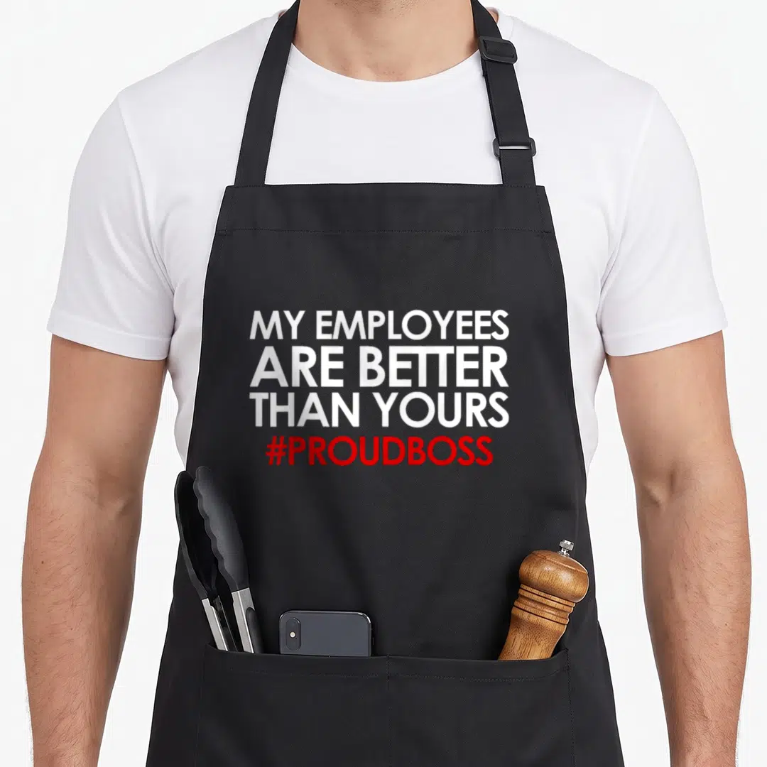 Appreciation employee aprons - White and red stacked text reading MY EMPLOYEES ARE BETTER THAN YOURS #PROUDBOSS — shown on a black cotton canvas apron against a white background