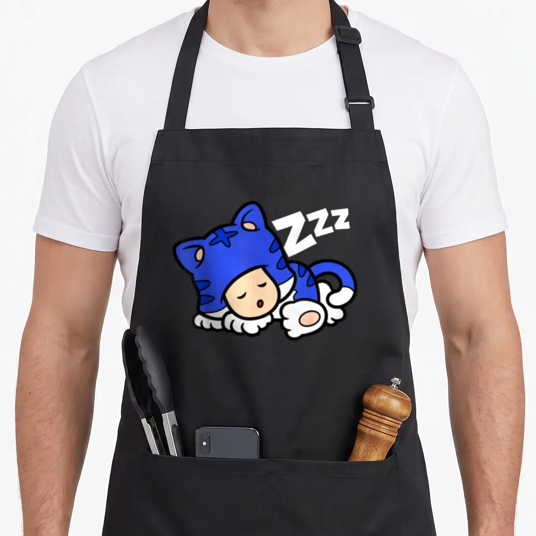 Blue toad apron - Character in blue cat suit curled up sleeping with white Zzz text floating above — shown on a black cotton canvas apron against a white background