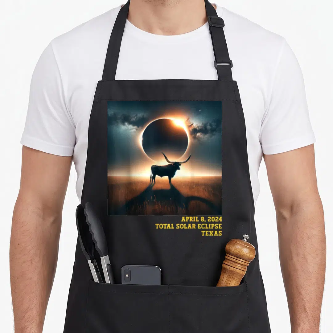 Commemorative texas apron - Bull silhouette under eclipse with stacked yellow text APRIL 8 2024 TOTAL SOLAR ECLIPSE — shown on a black cotton canvas apron against a white background
