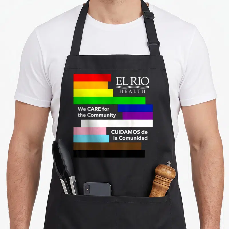 Care rio de janeiro apron - Progress Pride Flag stripes with EL RIO HEALTH text and bilingual care slogans — shown on a black cotton canvas apron against a white background