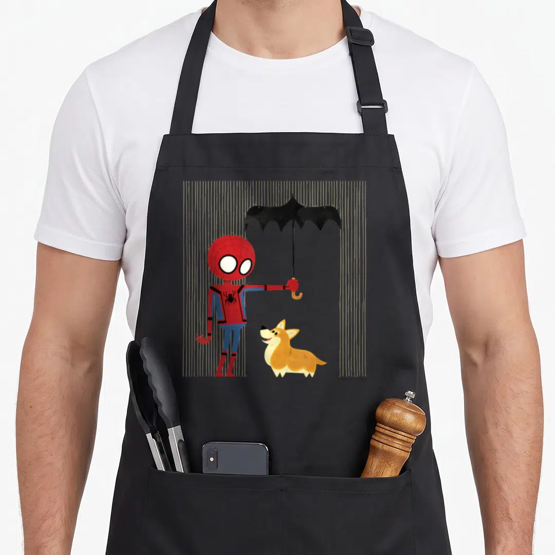 Far corgi apron - Spider-Man holding black umbrella over corgi amidst beige rain lines — shown on a black cotton canvas apron against a white background