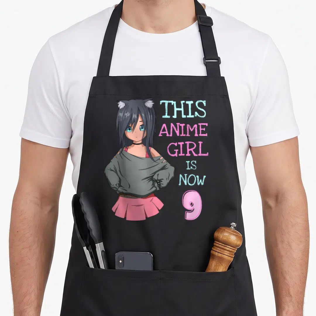 Birthday kawaii anime mom apron - Anime girl with cat ears and text THIS ANIME GIRL IS NOW 9 in pink and blue — shown on a black cotton canvas apron against a white background