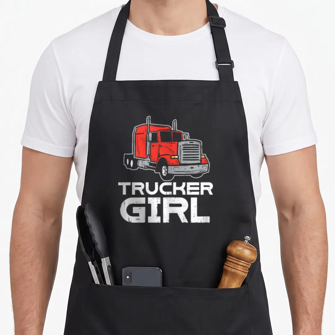 Wife semi truck apron - Red cartoon semi-truck above stacked white text TRUCKER GIRL on grey background — shown on a black cotton canvas apron against a white background