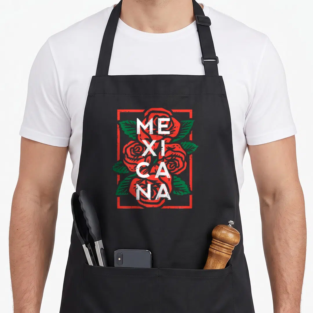 Rose mexican apron - MEXICANA text stacked over three roses with green leaves inside a red rectangular border — shown on a black cotton canvas apron against a white background