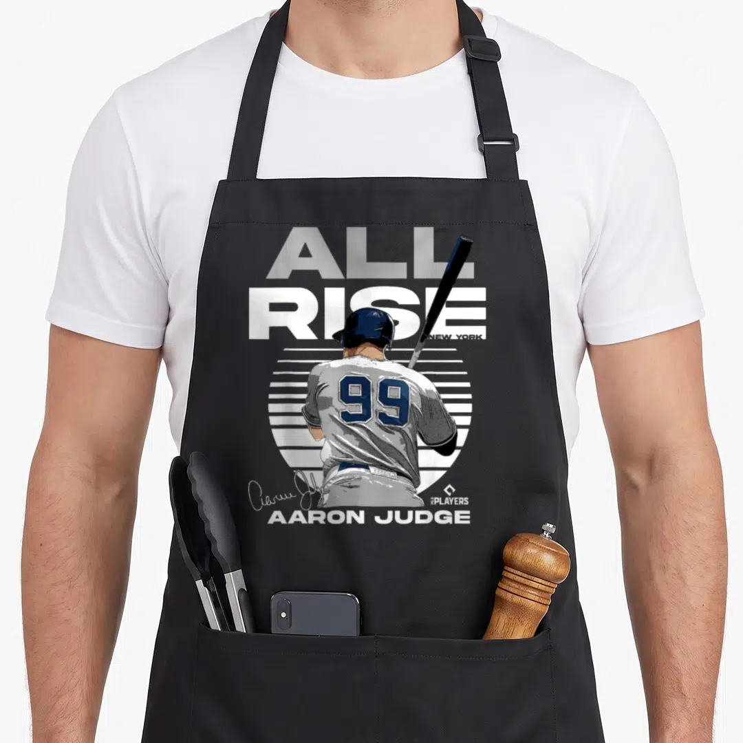 Rise new york apron - Baseball player from behind holding bat with ALL RISE text and 99 jersey number — shown on a black cotton canvas apron against a white background