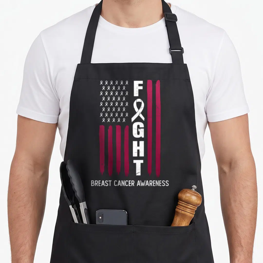 Flag month breast cancer awareness aprons - Distressed flag with vertical FIGHT, magenta stripes, white ribbons — shown on a black cotton canvas apron against a white background