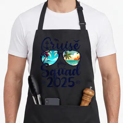 Cruise squad family aprons - Sunglasses with tropical reflections, cruise ship, anchor, and 2025 text in navy and orange — shown on a black cotton canvas apron against a white background