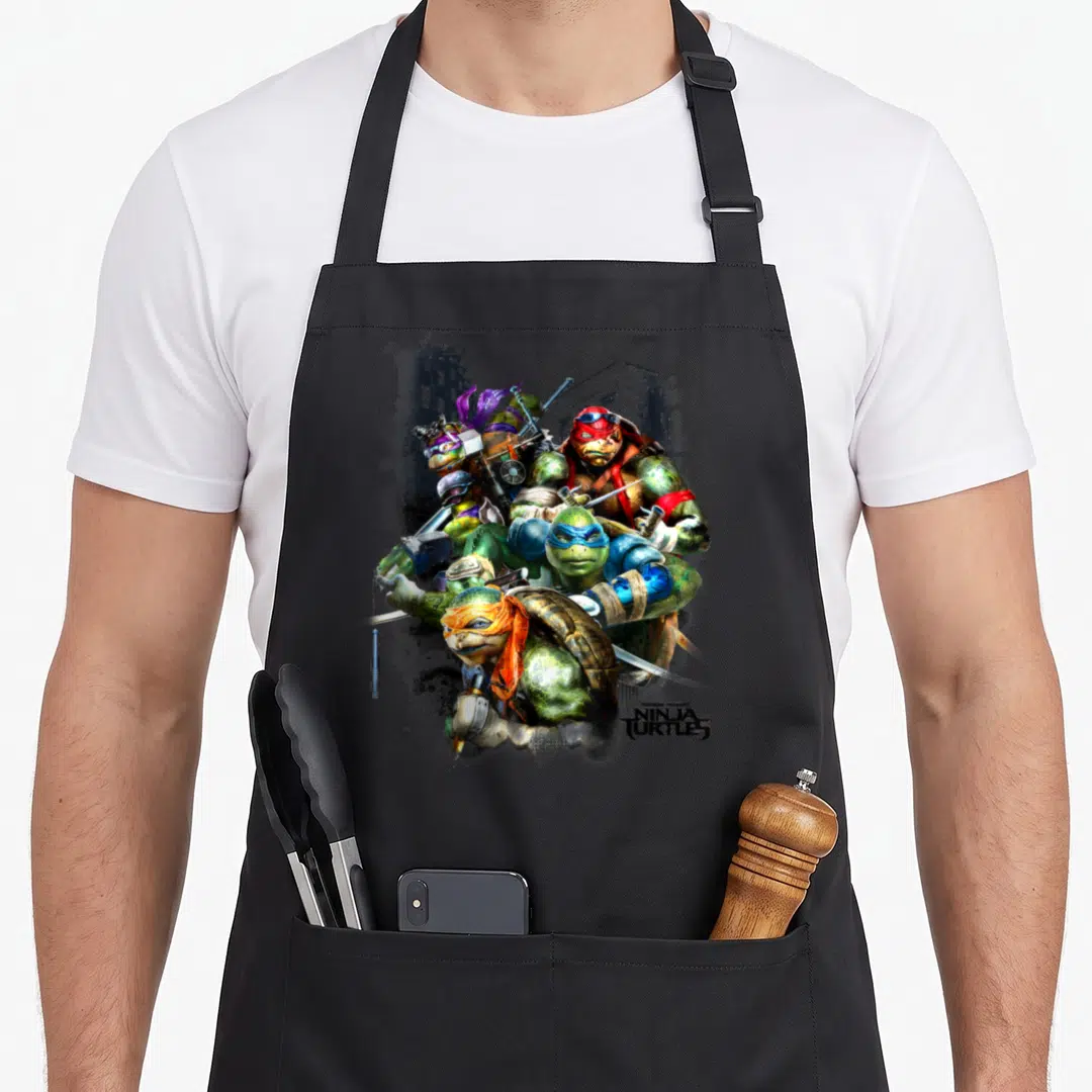 Ninja teenage cooking aprons - Four realistic turtles in dynamic pose with green grey red and blue details and bottom — shown on a black cotton canvas apron against a white background