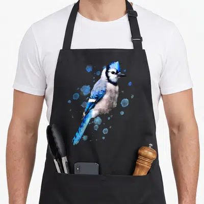 Watercolor birds apron - Blue jay watercolor illustration with scattered blue paint splatters on grey background — shown on a black cotton canvas apron against a white background
