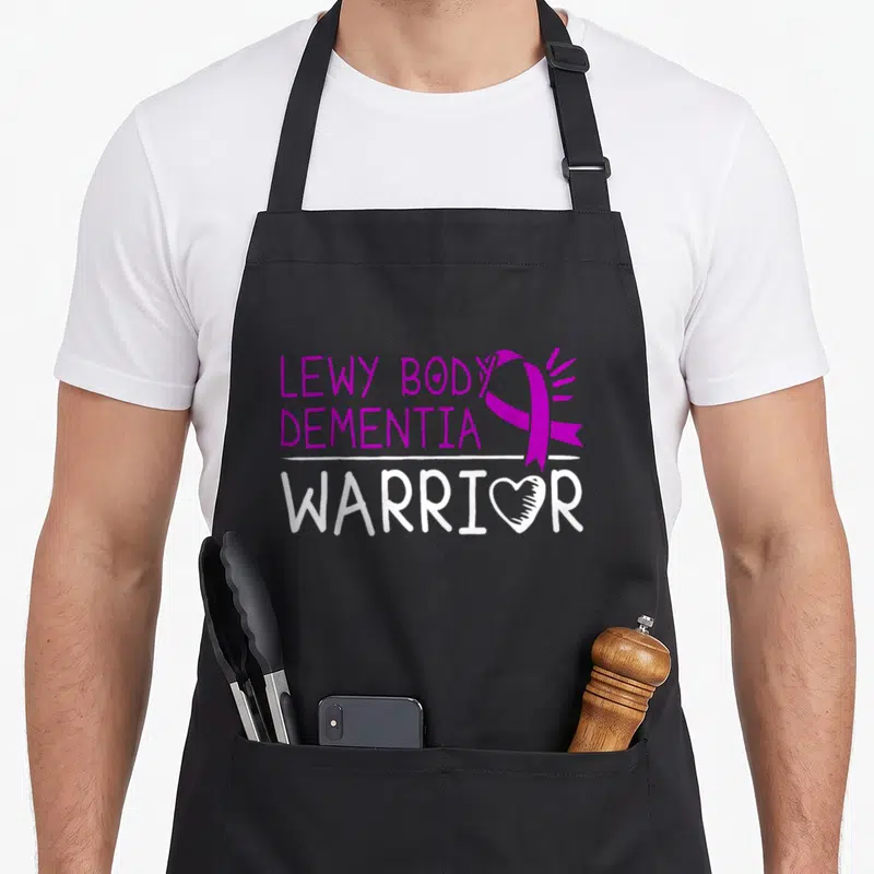 Ldb body apron - Purple and white LDB Warrior typography with ribbon and heart O — shown on a black cotton canvas apron against a white background