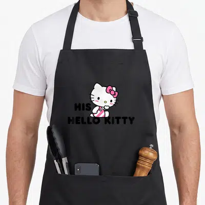 Dear couple apron - Hello Kitty cartoon with pink bow and text HIS HELLO KITTY in black — shown on a black cotton canvas apron against a white background