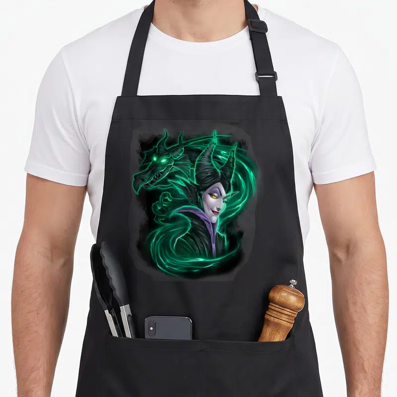 Magic beauty apron - Realistic Maleficent portrait with dragon head and glowing green energy swirls — shown on a black cotton canvas apron against a white background
