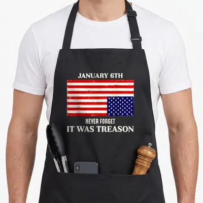 6th january birthday apron - Distressed US flag with cream text January 6th Never Forget It Was Treason — shown on a black cotton canvas apron against a white background