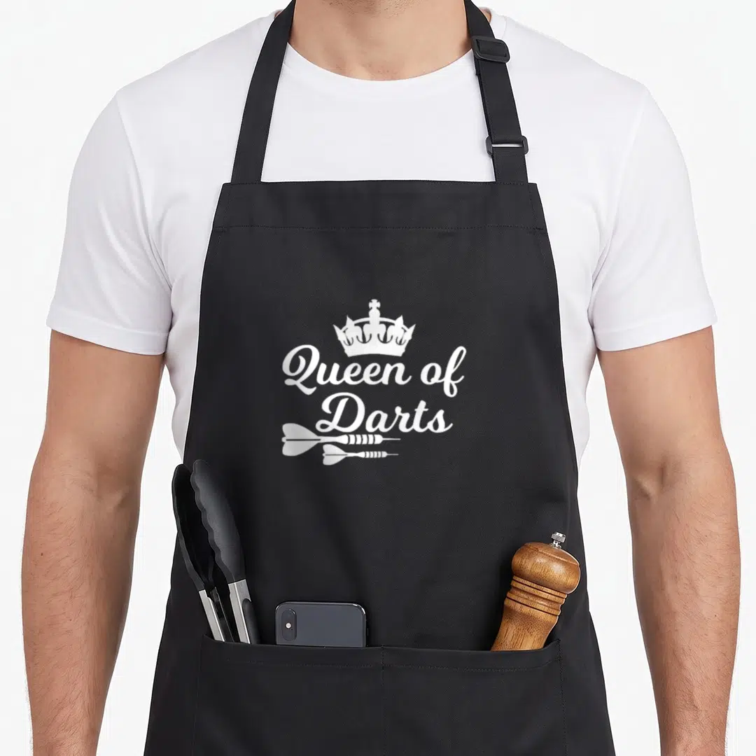 Dart queen apron - White crown and script text above two horizontal darts on dark background — shown on a black cotton canvas apron against a white background