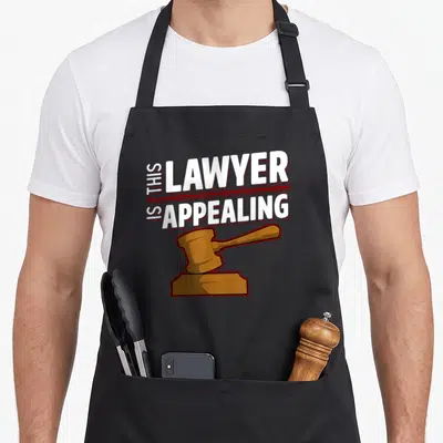 Appealing lawyer apron - This Lawyer Is Appealing text with brown cartoon gavel on black background — shown on a black cotton canvas apron against a white background