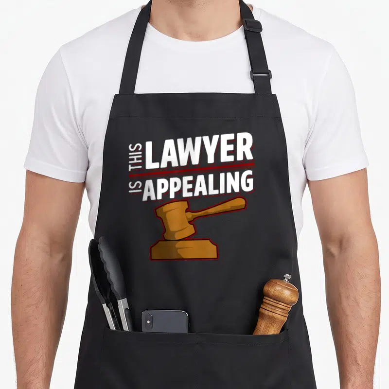 Appealing lawyer apron - This Lawyer Is Appealing text with brown cartoon gavel on black background — shown on a black cotton canvas apron against a white background