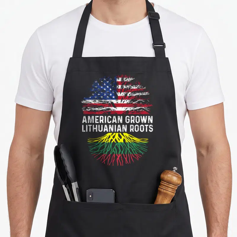 Lithuanian american flag apron - Tree with US flag canopy and Lithuanian flag roots with stacked text — shown on a black cotton canvas apron against a white background