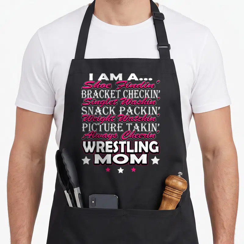 Wrestling mama apron - I AM A Shoe Findin Bracket Checkin Singlet Washin text with white and pink stars — shown on a black cotton canvas apron against a white background
