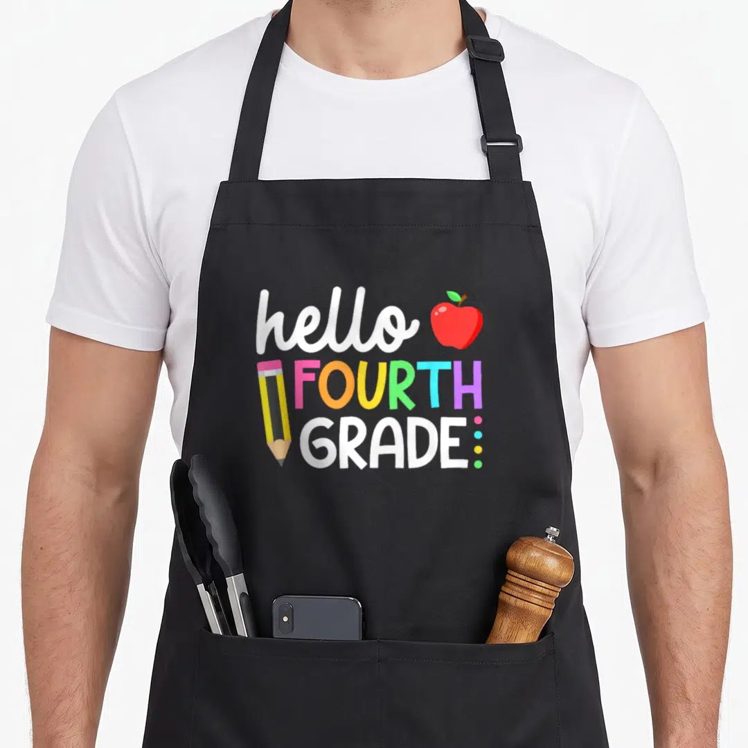 Fourth teacher apron - hello FOURTH GRADE text with red apple, pencil, and three colored dots in cartoon style — shown on a black cotton canvas apron against a white background