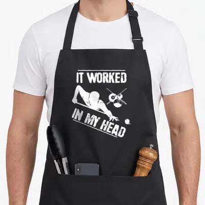 Worked billiards apron - Distressed white text IT WORKED IN MY HEAD above billiard player silhouette and numbered balls — shown on a black cotton canvas apron against a white background