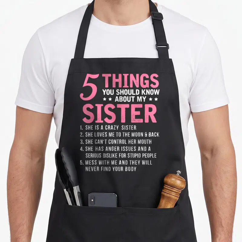 Should sister novelty apron - Pink and white 5 Things You Should Know About My Sister text with stars and numbered list — shown on a black cotton canvas apron against a white background