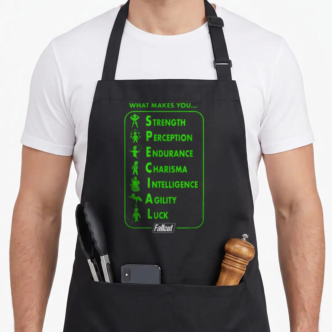 Video special aprons - Green S.P.E.C.I.A.L stat list with small figures and Fallout logo — shown on a black cotton canvas apron against a white background