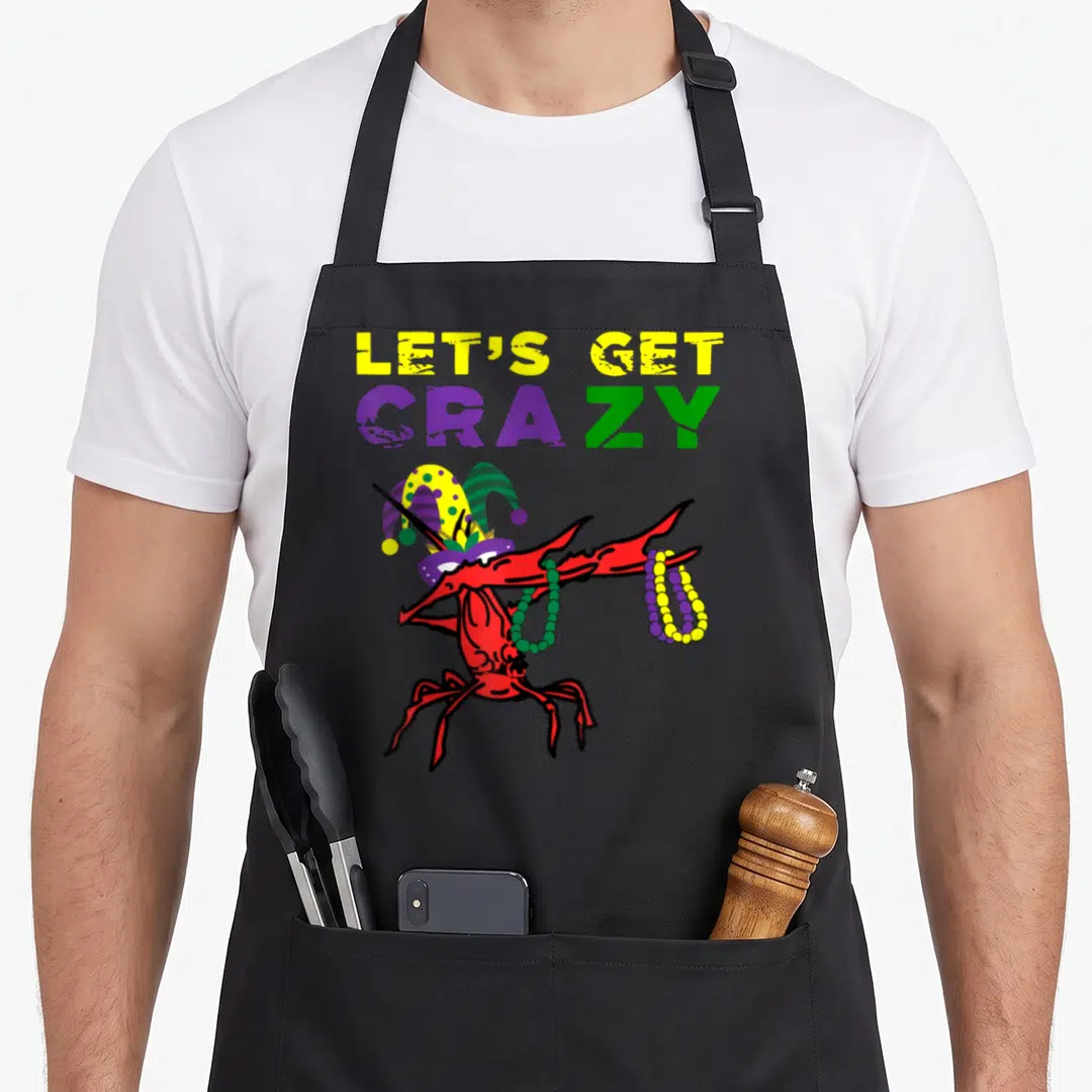 Dabbing fat chef apron - LET'S GET CRAZY text above red crawfish dabbing with jester hat and beads — shown on a black cotton canvas apron against a white background
