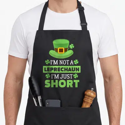 Vintage leprechaun st patrick day aprons - Green leprechaun hat above stacked white and grey text reading I'M NOT — shown on a black cotton canvas apron against a white background