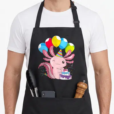 Pet birthday apron - Pink axolotl party hat three-tier cake five balloons confetti cartoon — shown on a black cotton canvas apron against a white background