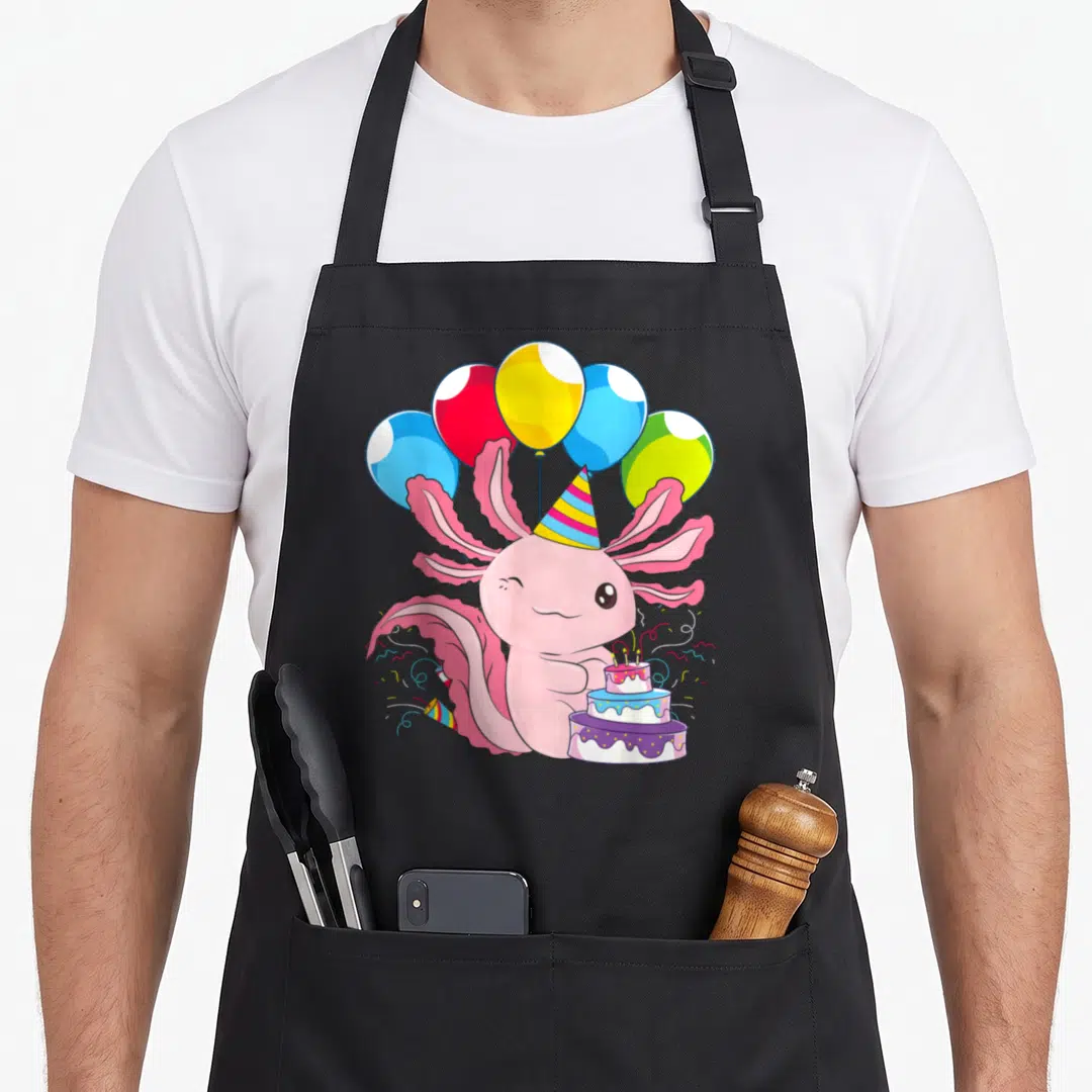 Pet birthday apron - Pink axolotl party hat three-tier cake five balloons confetti cartoon — shown on a black cotton canvas apron against a white background
