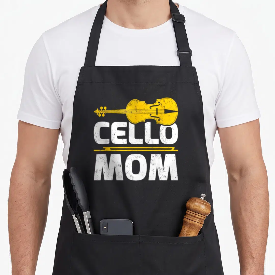 Funny music cello apron - Yellow cello and bow with distressed white CELLO MOM text on black — shown on a black cotton canvas apron against a white background