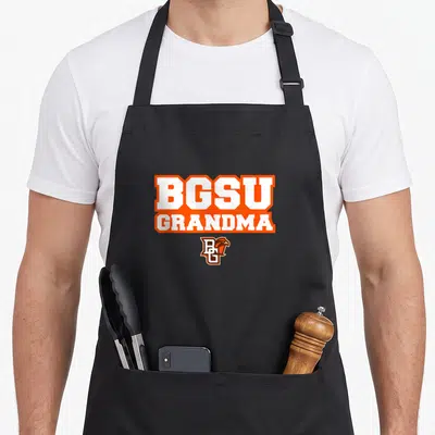 Bowling grandma apron - BGSU GRANDMA text in white with orange borders above a small falcon logo — shown on a black cotton canvas apron against a white background