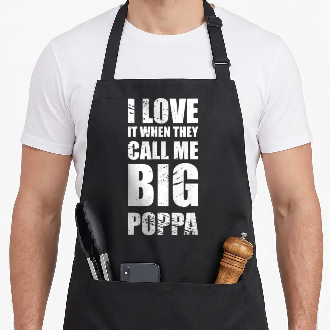 Call poppa father day apron - White distressed text reading I LOVE IT WHEN THEY CALL ME BIG POPPA stacked vertically — shown on a black cotton canvas apron against a white background